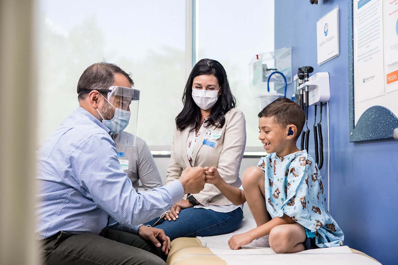 Dr. Pinto fist bumps a pediatric patient