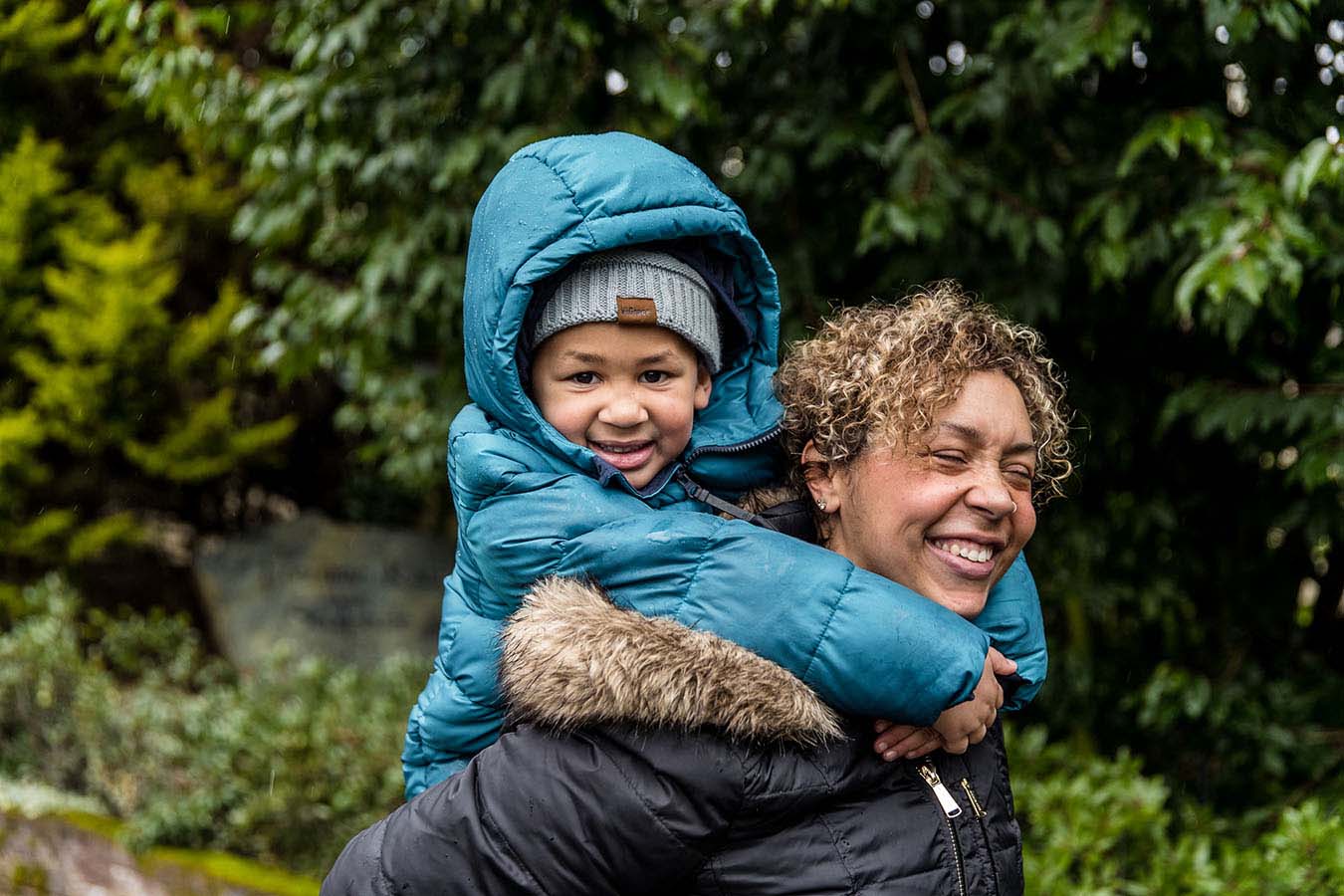 His mom gives a boy a piggyback ride