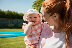 A mother holds a baby outside