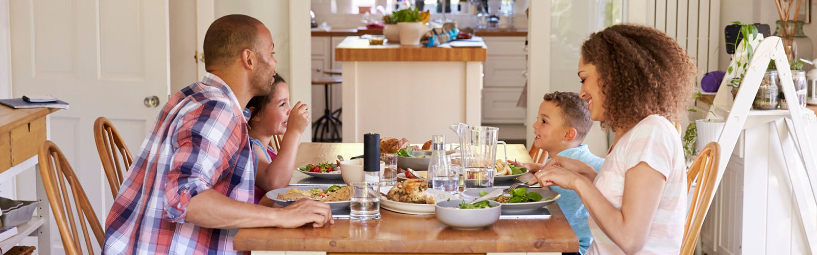 A family talks as they eat at the dining table.