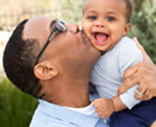 Dad kissing Baby's cheek