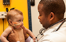 Dr. Andre Dick with holds a baby patient